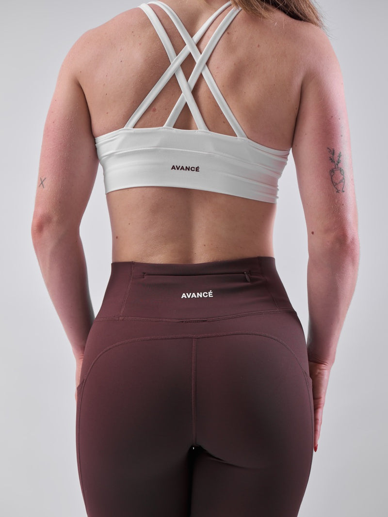 Back view of cross-back bra with burgundy leggings