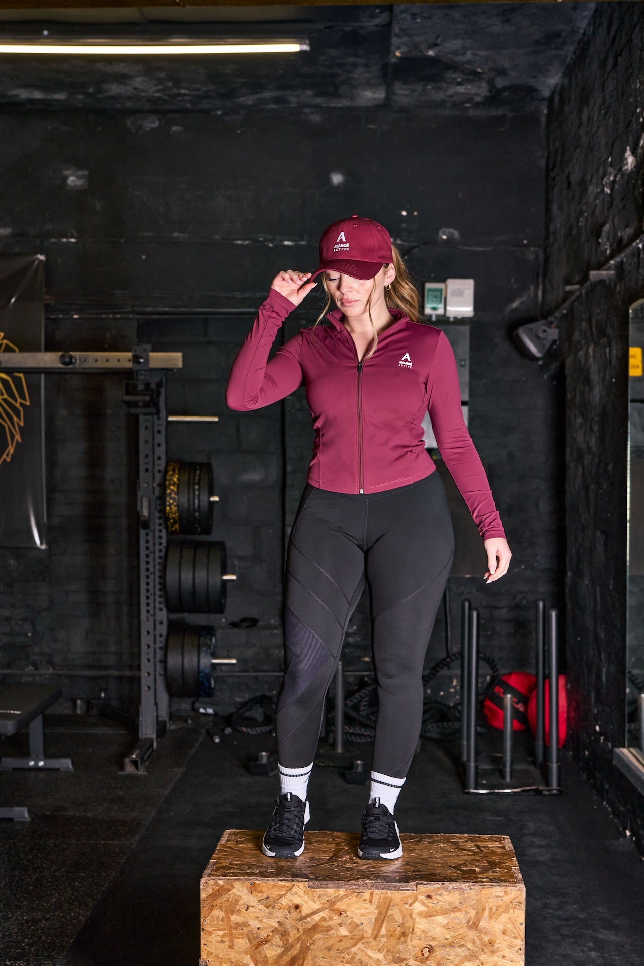 avancé active model in the gym wearing activewear and standing on a box